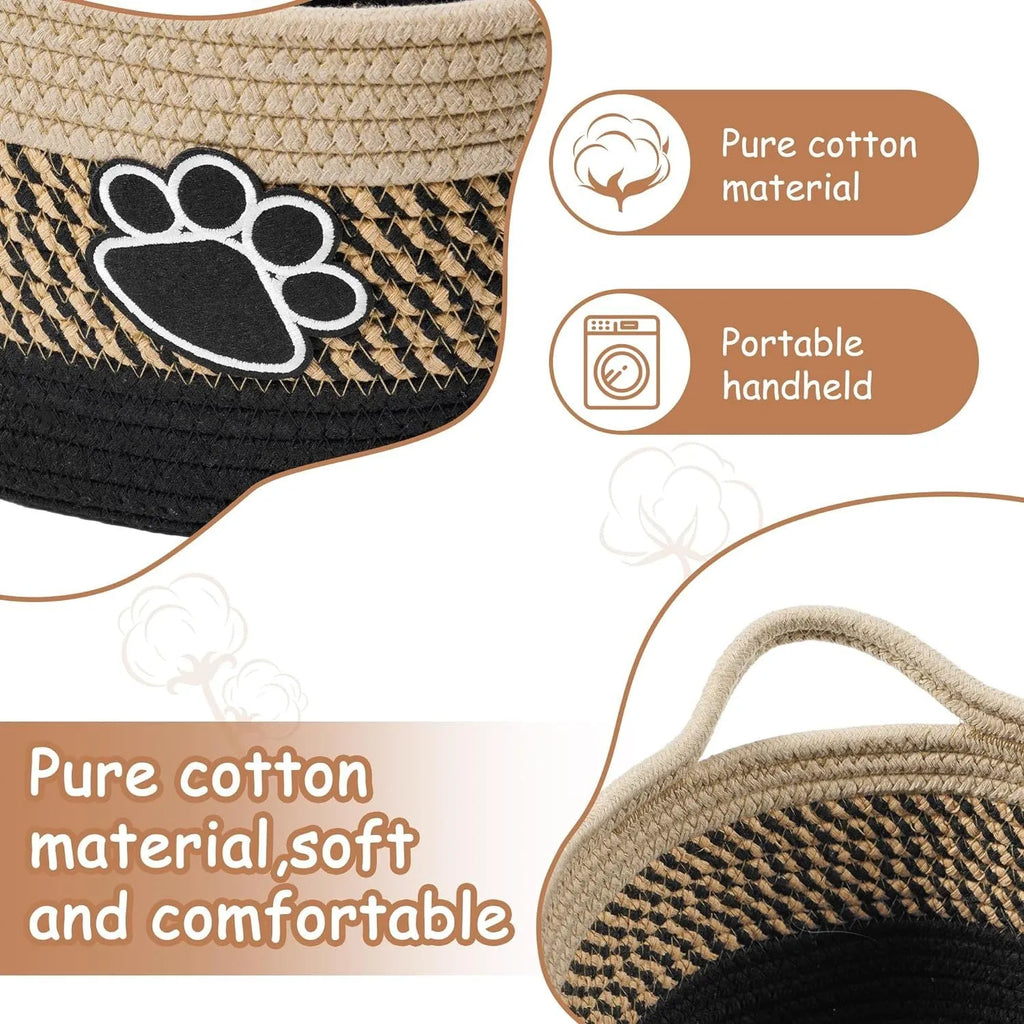 Small light beige handmade cotton rope storage basket with wooden handle on a table.