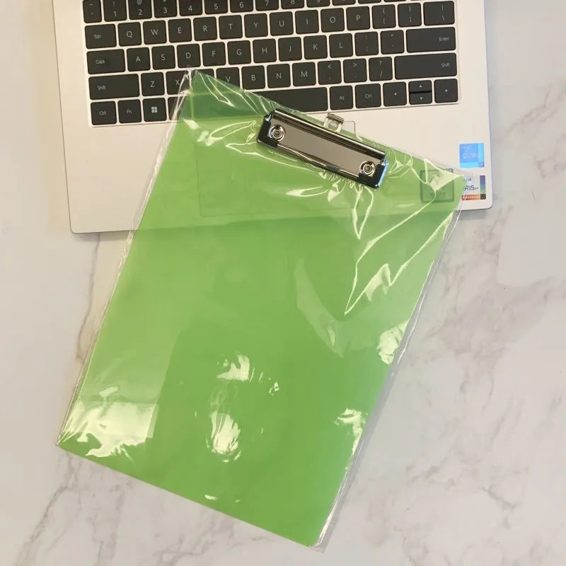 A4 transparent plastic writing board pad with metal clip in blue colour on a desk