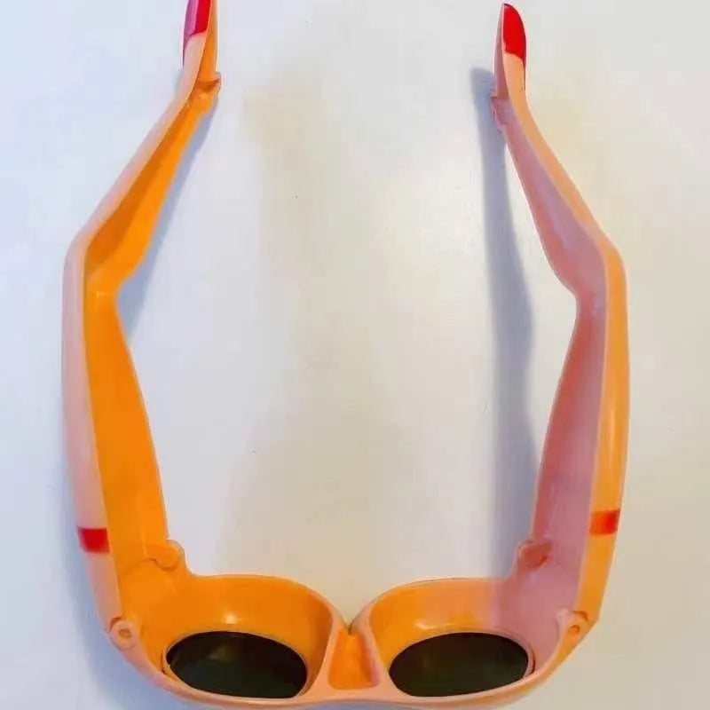 Orange plastic novelty sunglasses with leg and hip design measuring 15x20cm