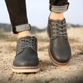 Men's black mid-top waterproof Martin boots with a rubber sole on a white background.
