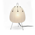 Japanese style handmade rice paper lantern table lamp with aluminium base on a wooden table.