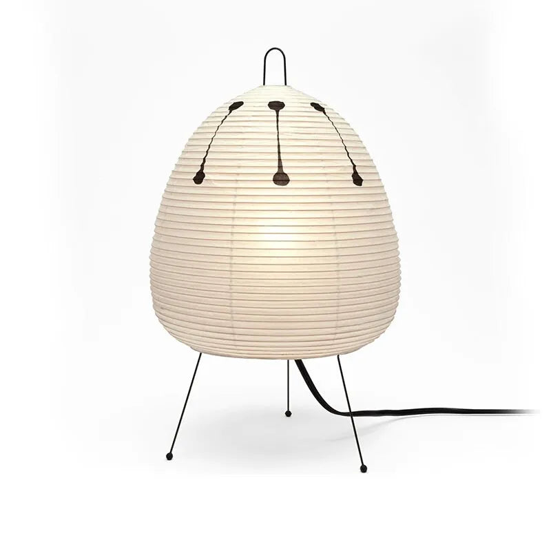 Japanese style handmade rice paper lantern table lamp with aluminium base on a wooden table.