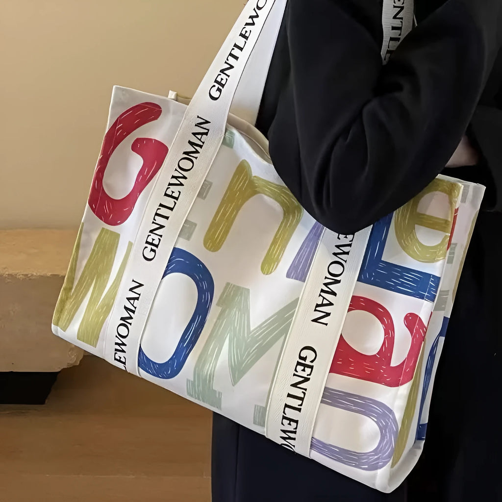 Large canvas women's travel tote bag with print design options including black letters and patterns.
