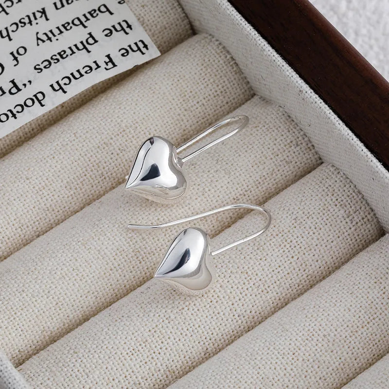 Silver tone heart-shaped earrings with glossy finish and Korean style design