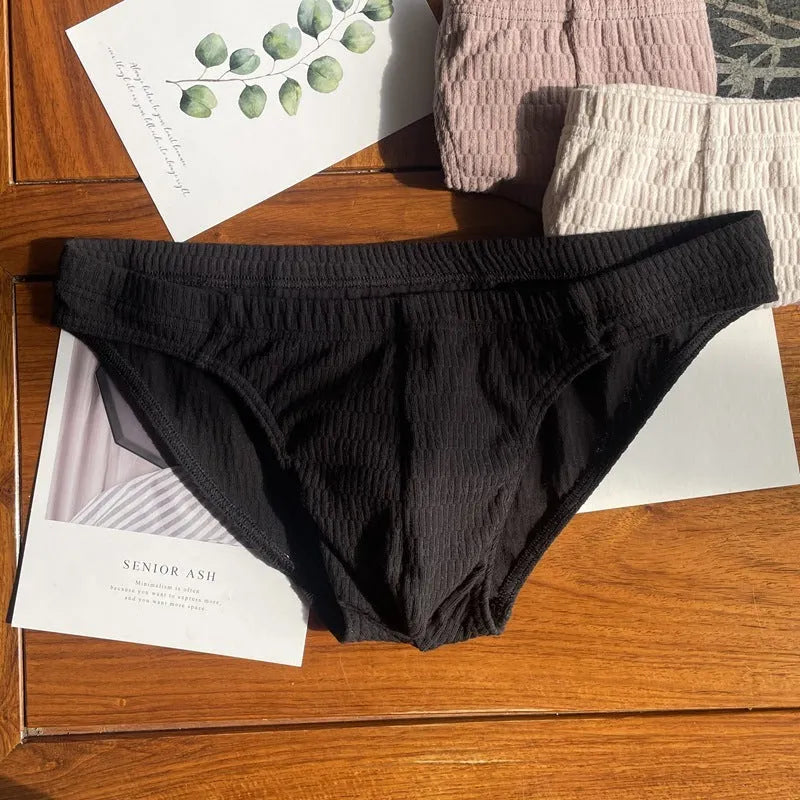 Men's solid colour cotton triangle briefs with a mid-waist waistband on a white background.