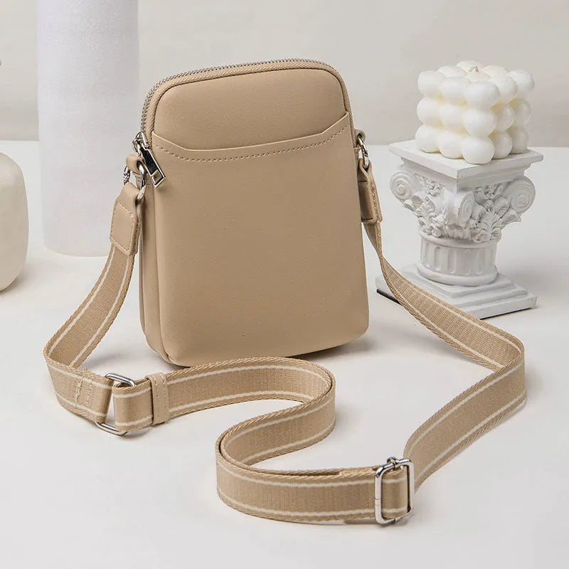 Solid colour small crossbody mobile phone bag in beige, showing front view and adjustable strap.