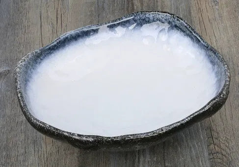Japanese ceramic sashimi bowl with irregular shape and floral decoration pattern