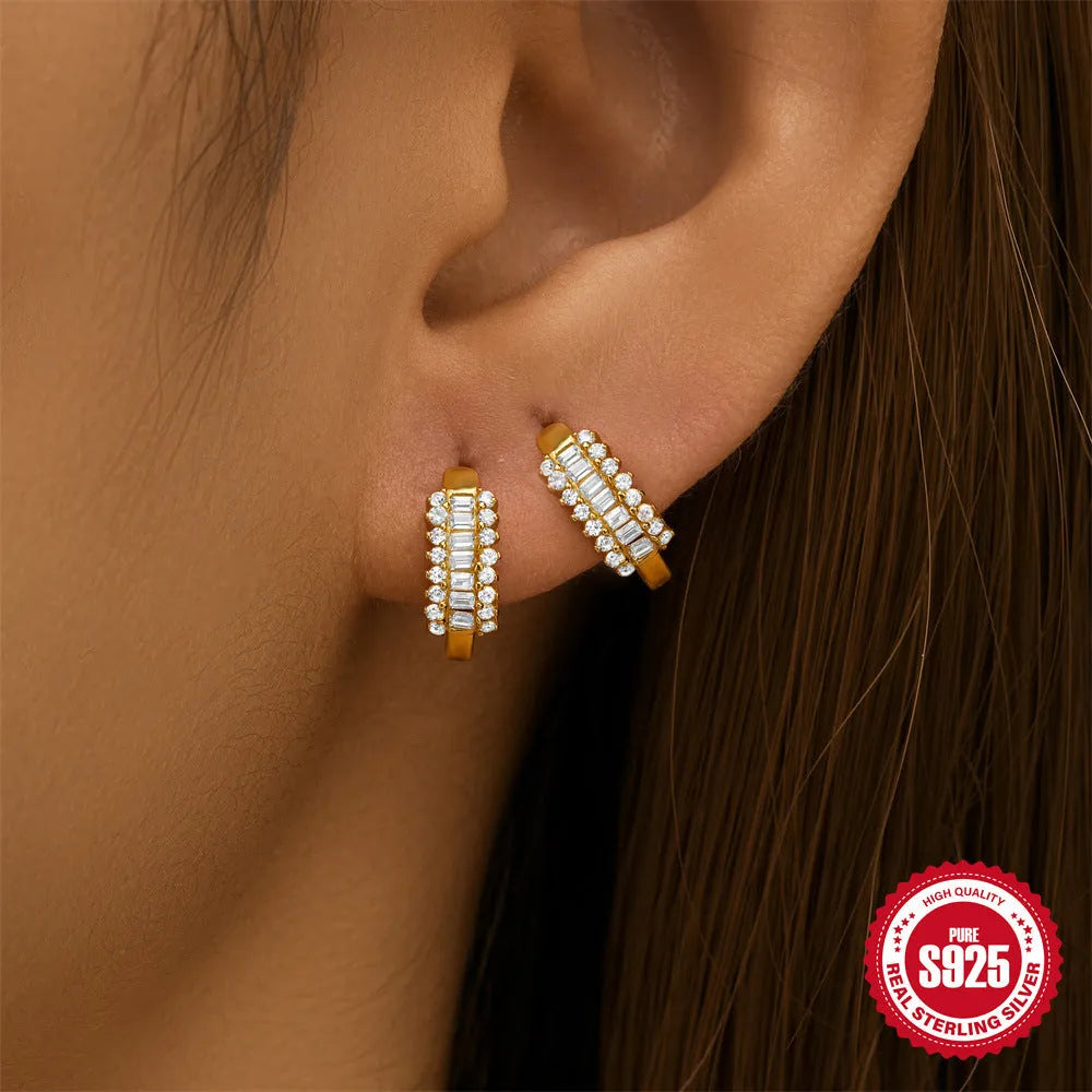 Sterling silver geometric stud earrings with a small round shape and classic diamond detail on a white background.