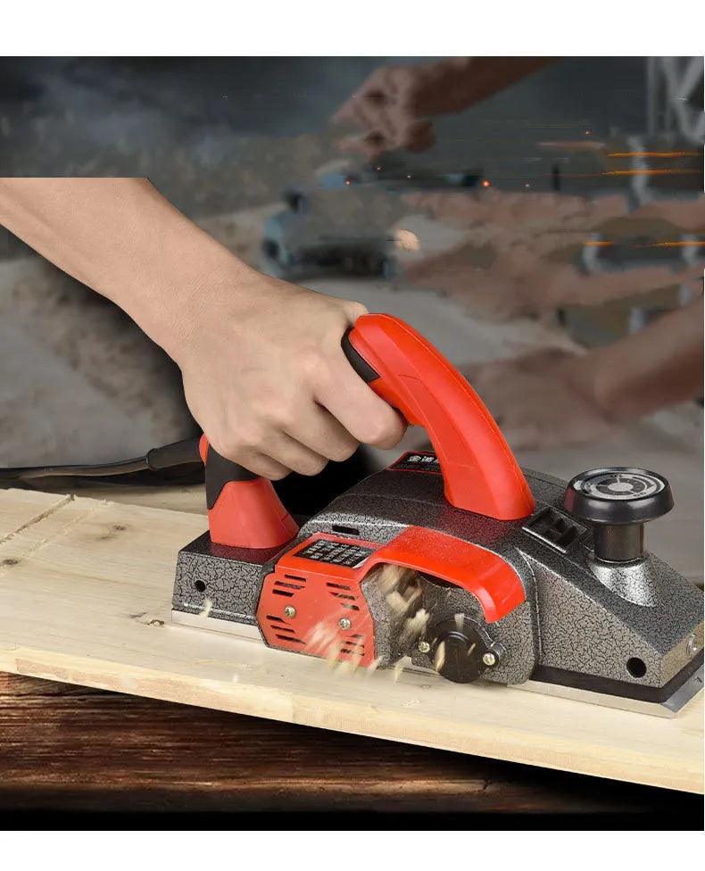 Red aluminium shell electric wood planer tool with 82mm planing width on a workbench.