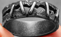 Stainless steel punk double ring with a dark stitching design on a plain background.