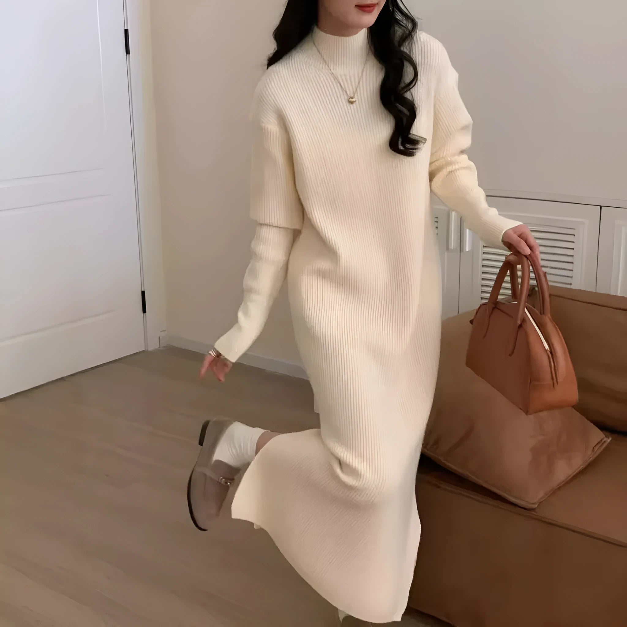 Woman wearing a beige high-waist knitted midi dress with long sleeves and a half turtleneck neckline.