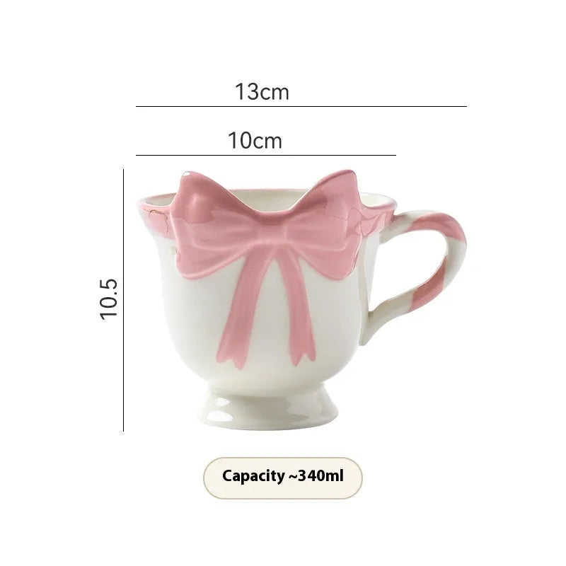 Ceramic mug with heart bow design in cute style showing Black Pink and White Powder colour options