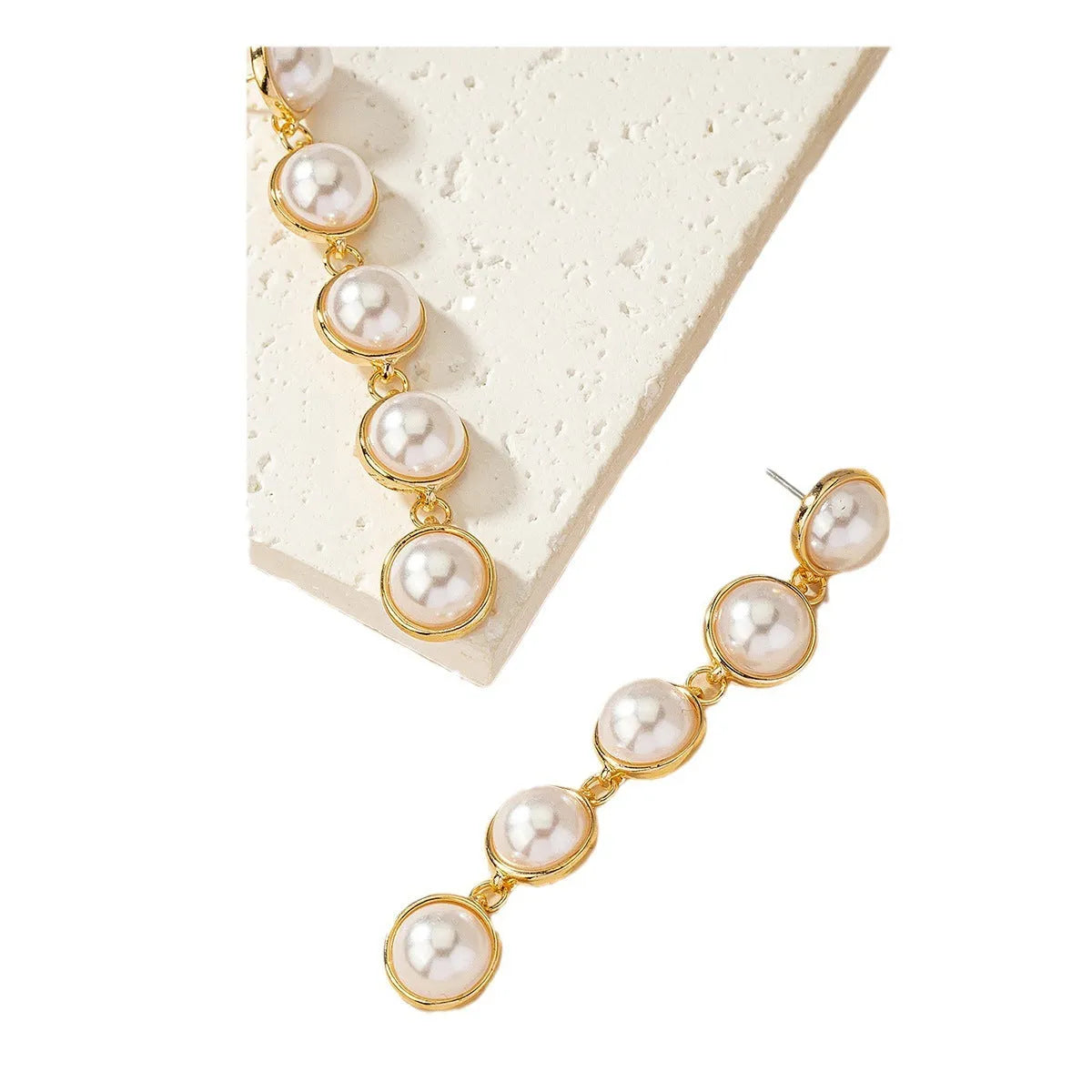 White metal drop tassel earrings with pearl water flow design on display