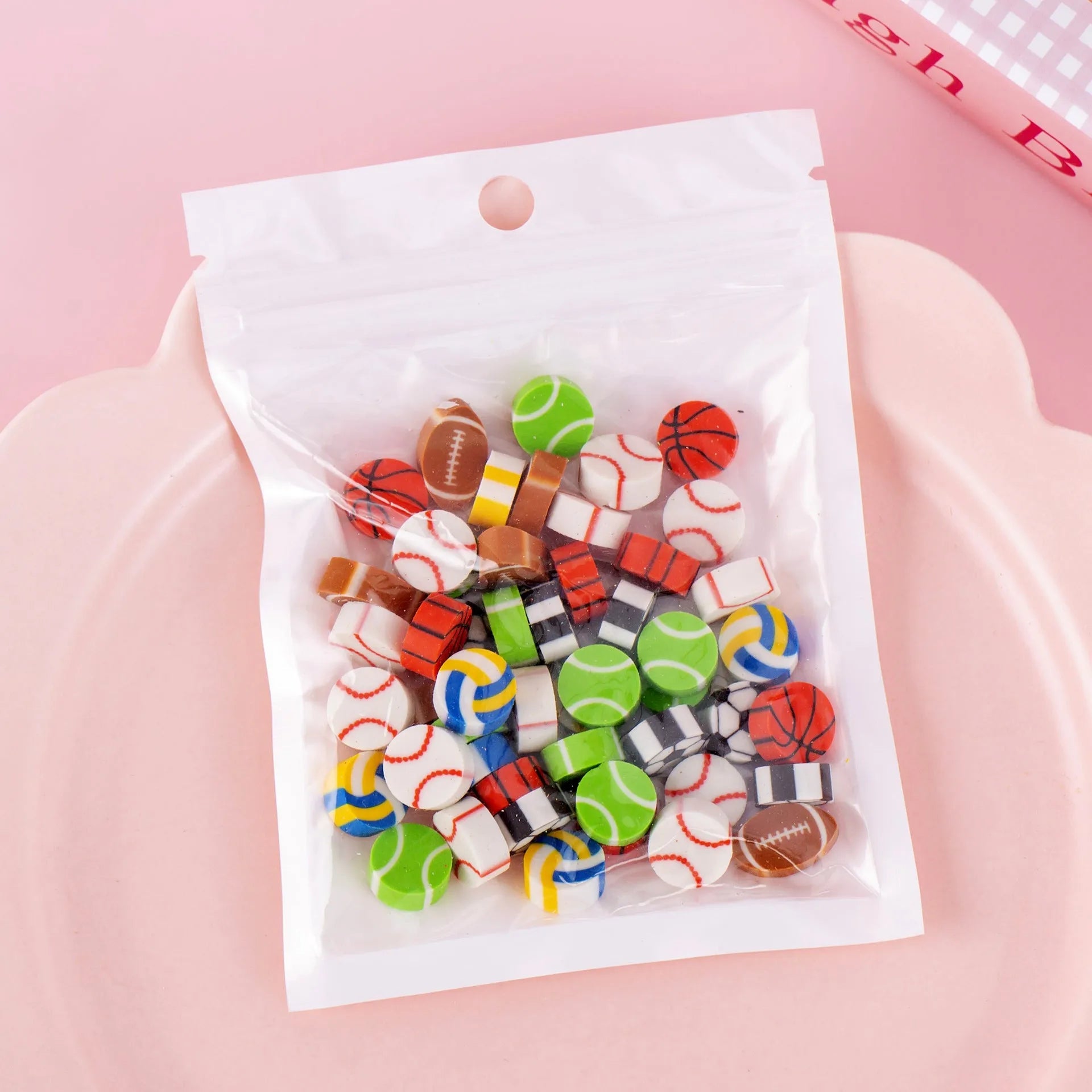 50 small colourful cartoon erasers in a pearlescent bag showing fruit, animal, cake, and Halloween themes.