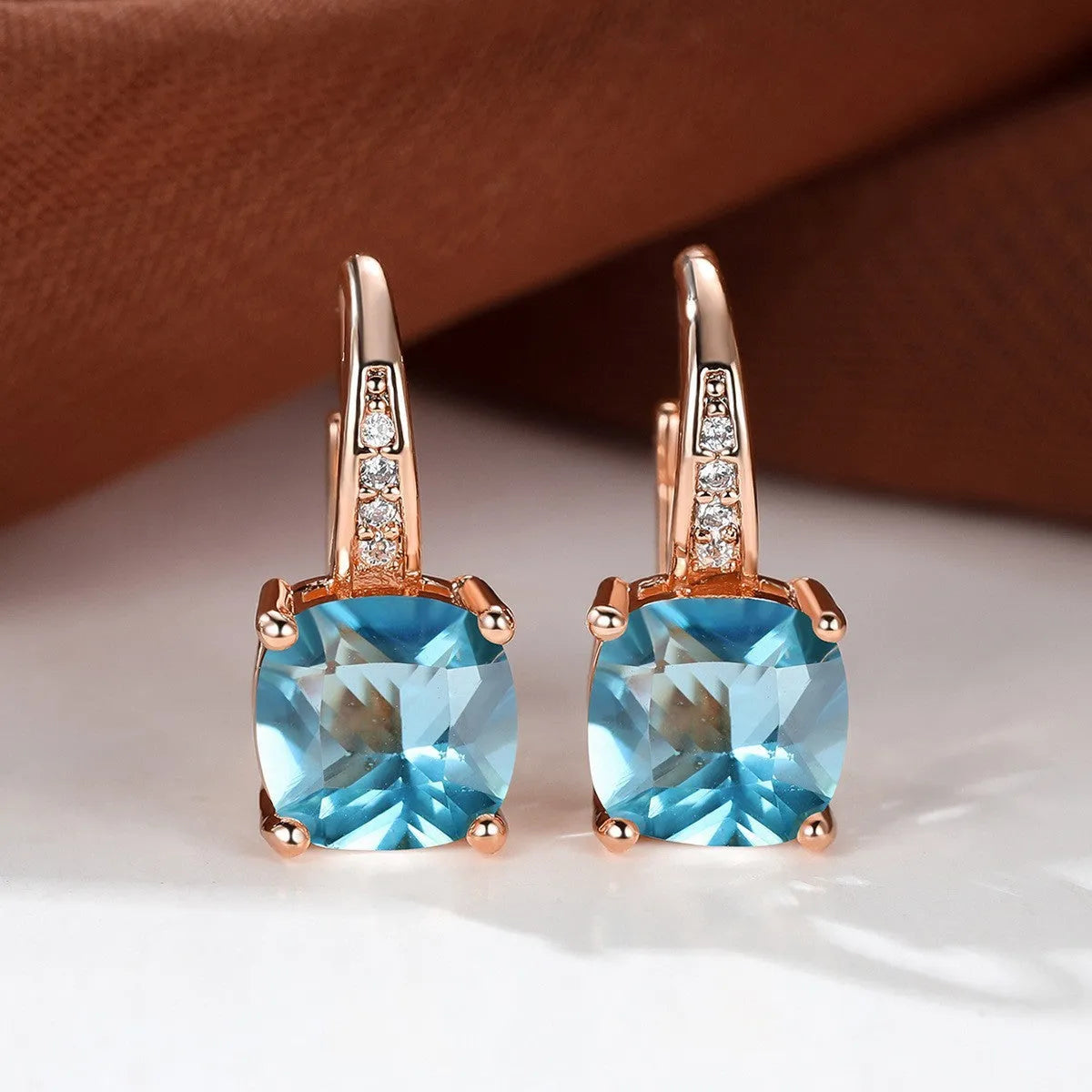 Square geometric ear hook earrings with zircon stones in an electroplated copper setting.