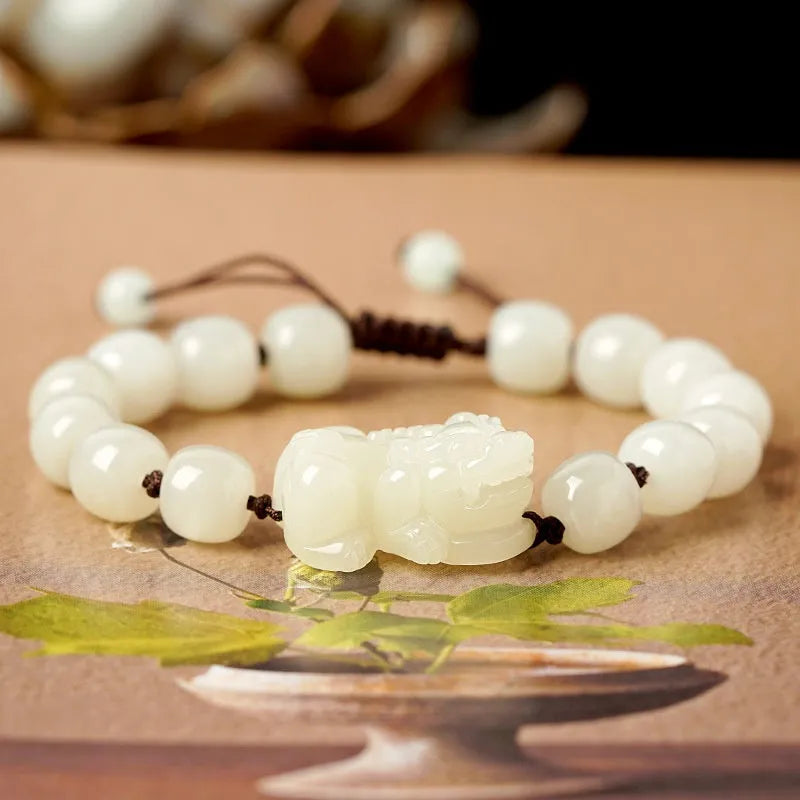 A Hetian jade bracelet with braided black and red rope in a Chinese style design.