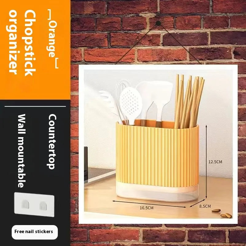Plastic wall-mounted chopsticks tube and spoon basket organiser in beige, dark green, or orange.