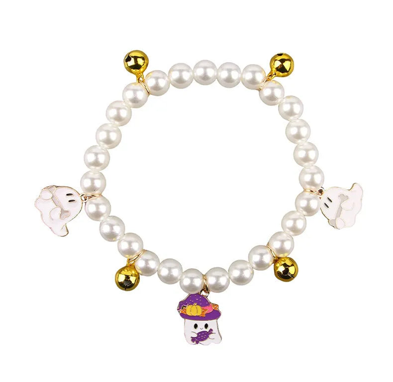 Adjustable simulated pearl necklace cat collar with a Halloween pumpkin charm in purple ghost, skull, or smile designs.