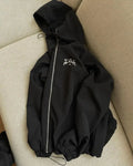 Grey loose-fit men's hooded sunscreen jacket in British style hanging on a hanger.