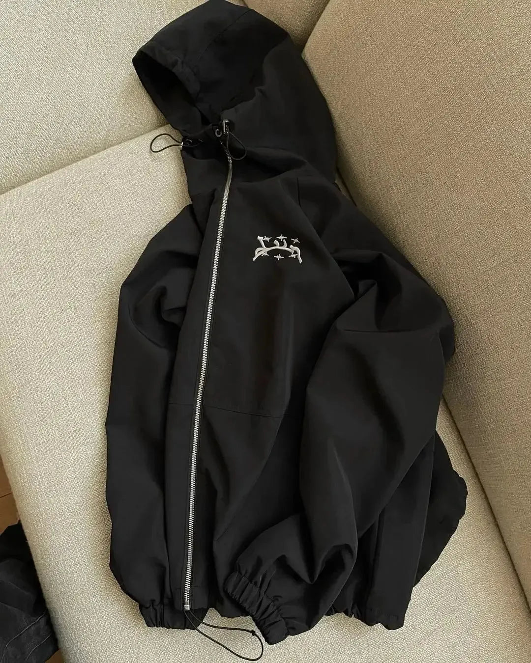 Grey loose-fit men's hooded sunscreen jacket in British style hanging on a hanger.