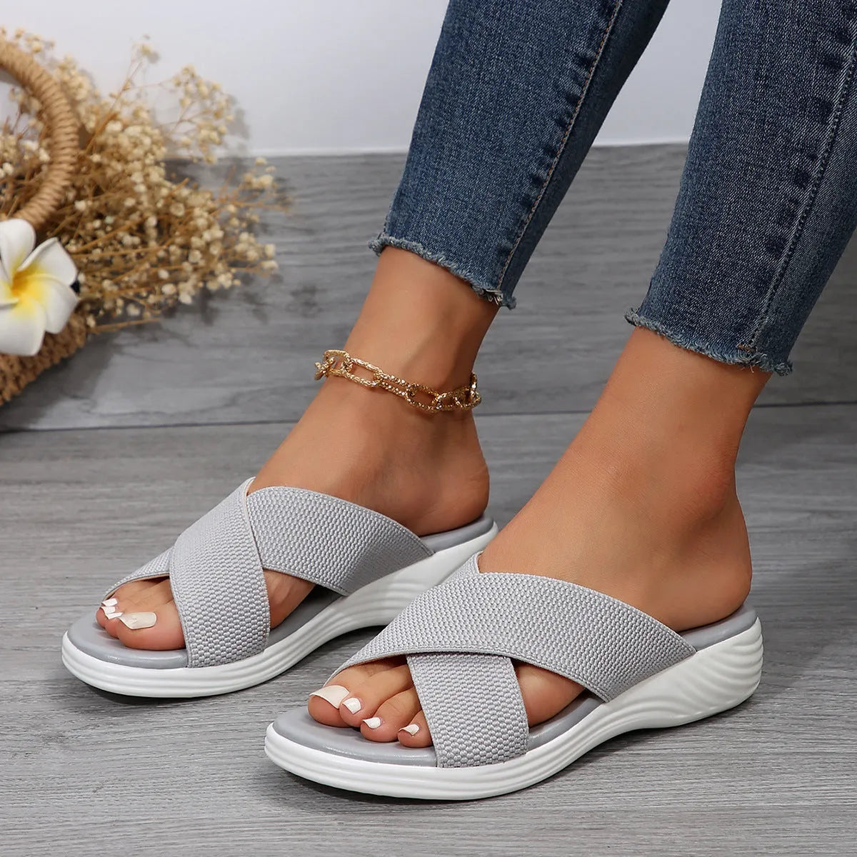 Black women's peep-toe wedge slippers with a thick rubber sole on a plain background.