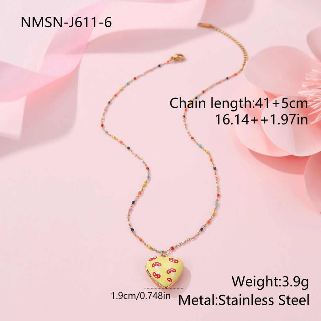 Women's stainless steel necklace with 18K gold plating showing heart pendant with fruit designs