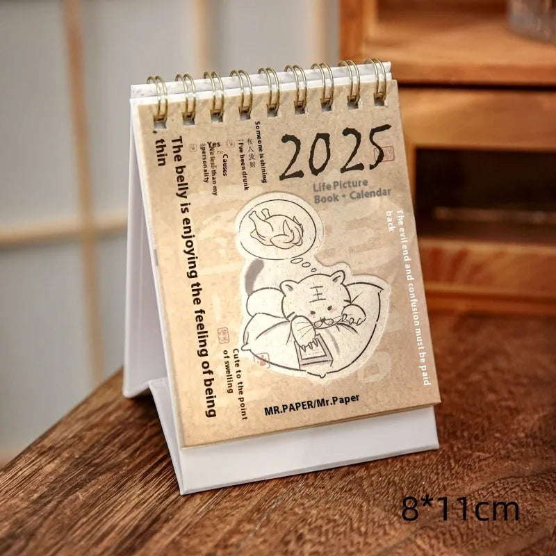 Mini A6 paper desk calendar for 2025 open to a monthly page with coffee-themed design.