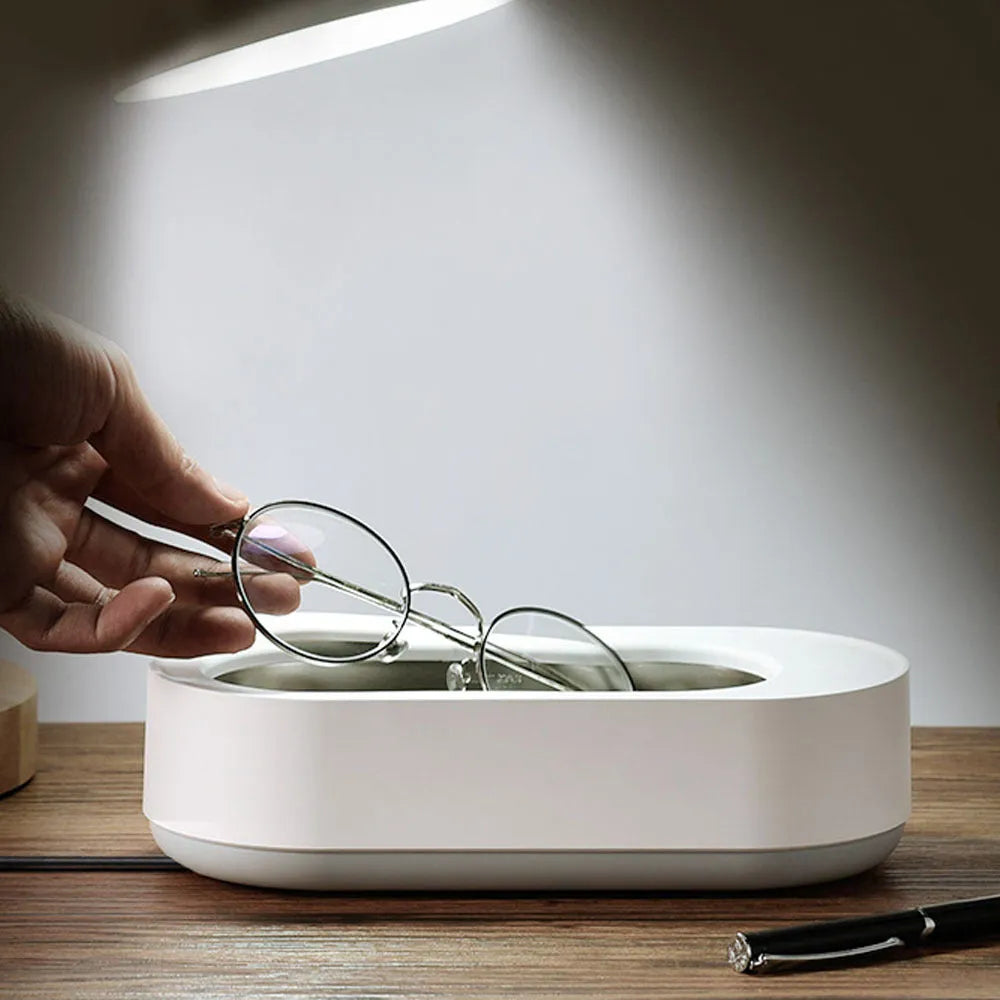 White portable ultrasonic cleaner machine with stainless steel tank for cleaning jewellery and glasses.