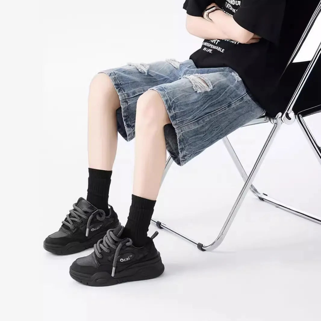 Loose fit ripped denim shorts in black and blue washes on a size chart