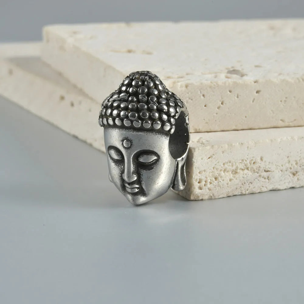 Stainless steel geometric earrings with hollow skull and Buddha head design in electroplated colour options.