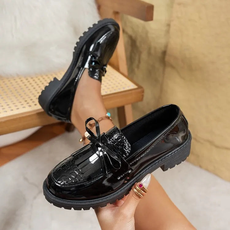 Women's brown and black loafer shoes with decorative bow detailing