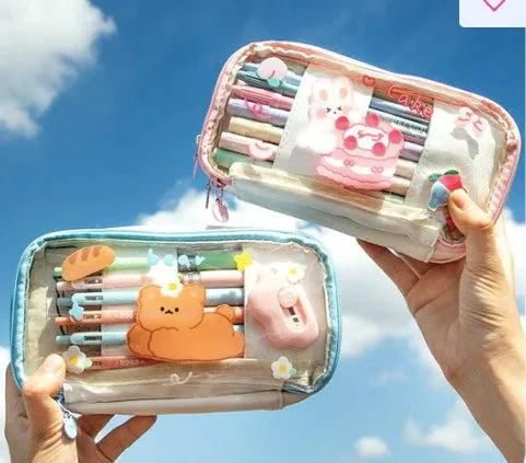 Transparent pink heart-shaped pen case with a cartoon cake and rabbit design, shown open.