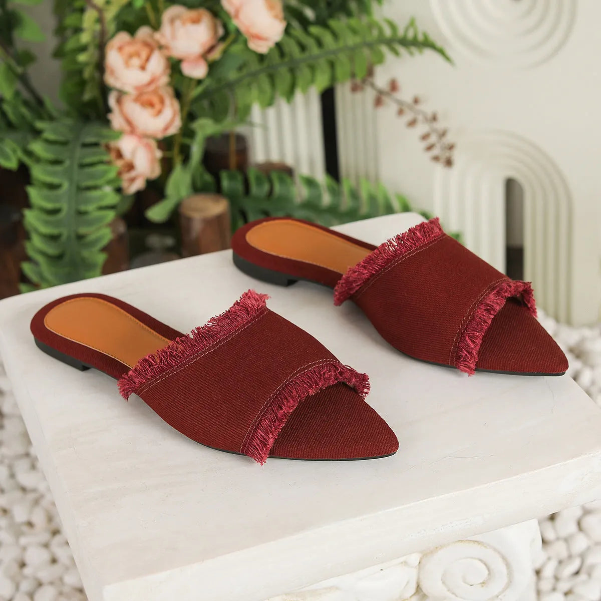 Women's flat denim slippers with tassel detail in apricot colour on a white background