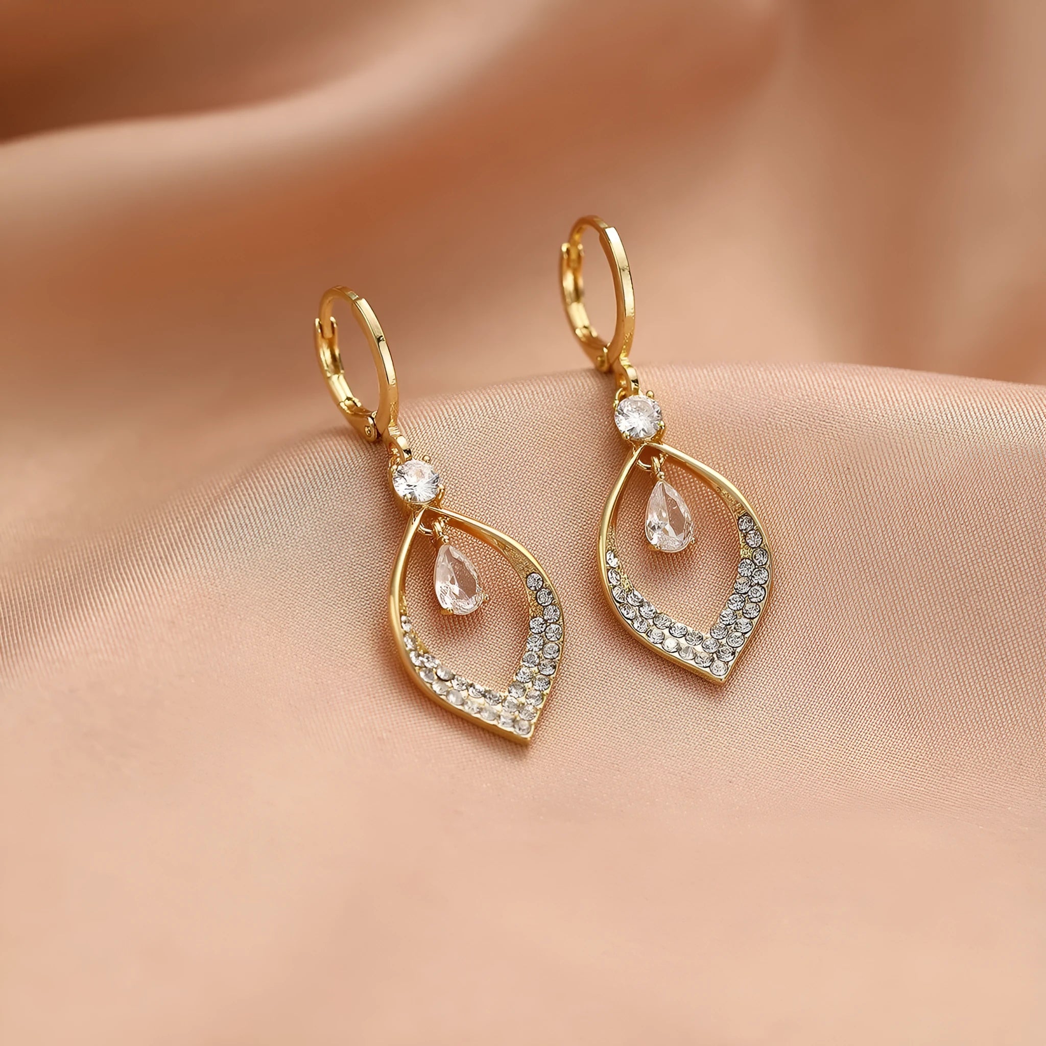 Copper electroplated women's earrings with a teardrop shape, water drop tassels, and zircon stones in gold colour.