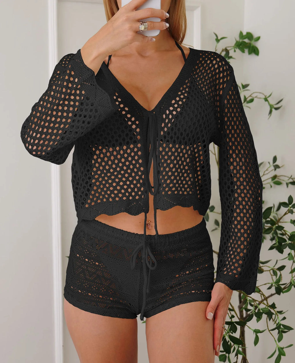 Short women's cardigan blouse with bell sleeves in a hollow woven cotton-like fabric.