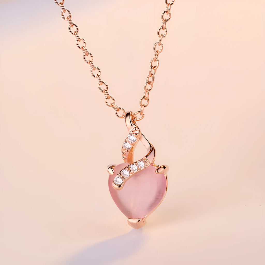 Rose gold cross chain necklace with a pink heart-shaped synthetic crystal pendant.