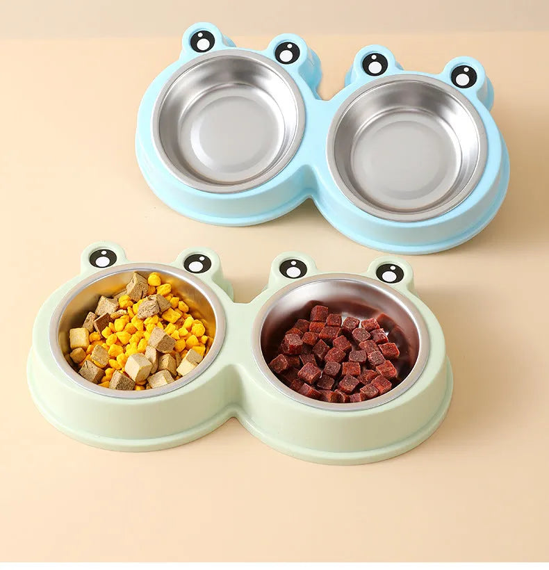 Stainless steel frog-shaped double bowl for pet food and water in blue, green, or pink.