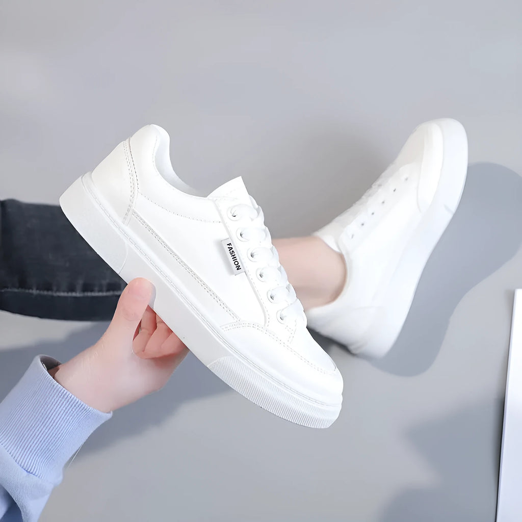 Women's brown and white Korean-style low-top sneakers with artificial PU uppers on solid background.