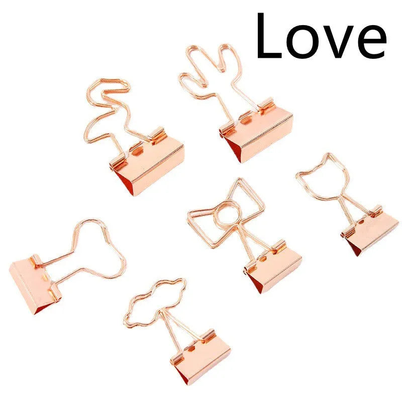 Gold long tail metal clip with decorative charm shape for document organisation