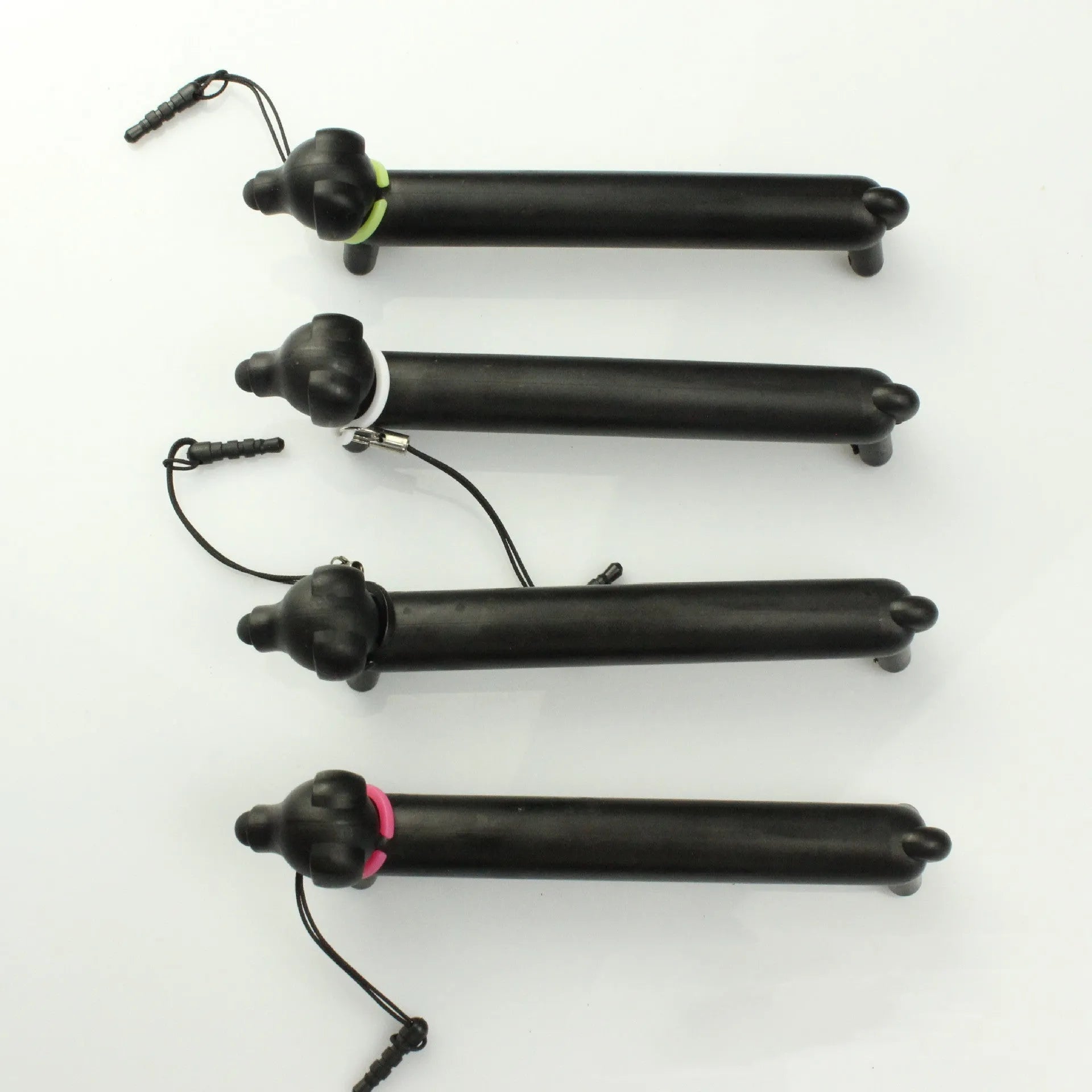 Black dog-shaped touch screen stylus with conductive body shown next to smartphone demonstrating phone holder function