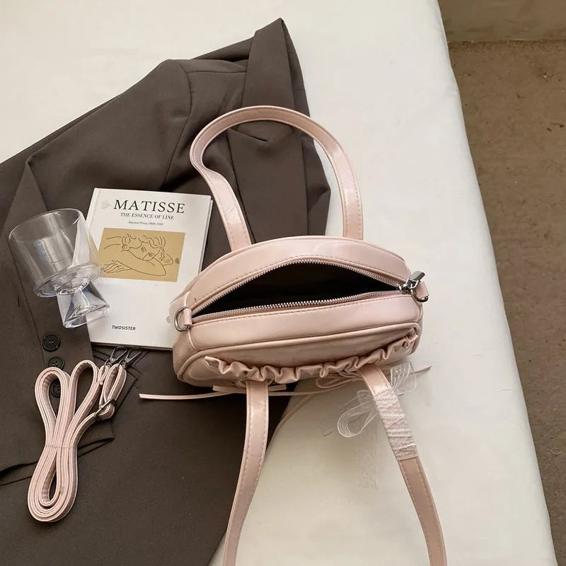 Milky white women's PU shoulder bag with a black bandage bow and sewing thread detail.