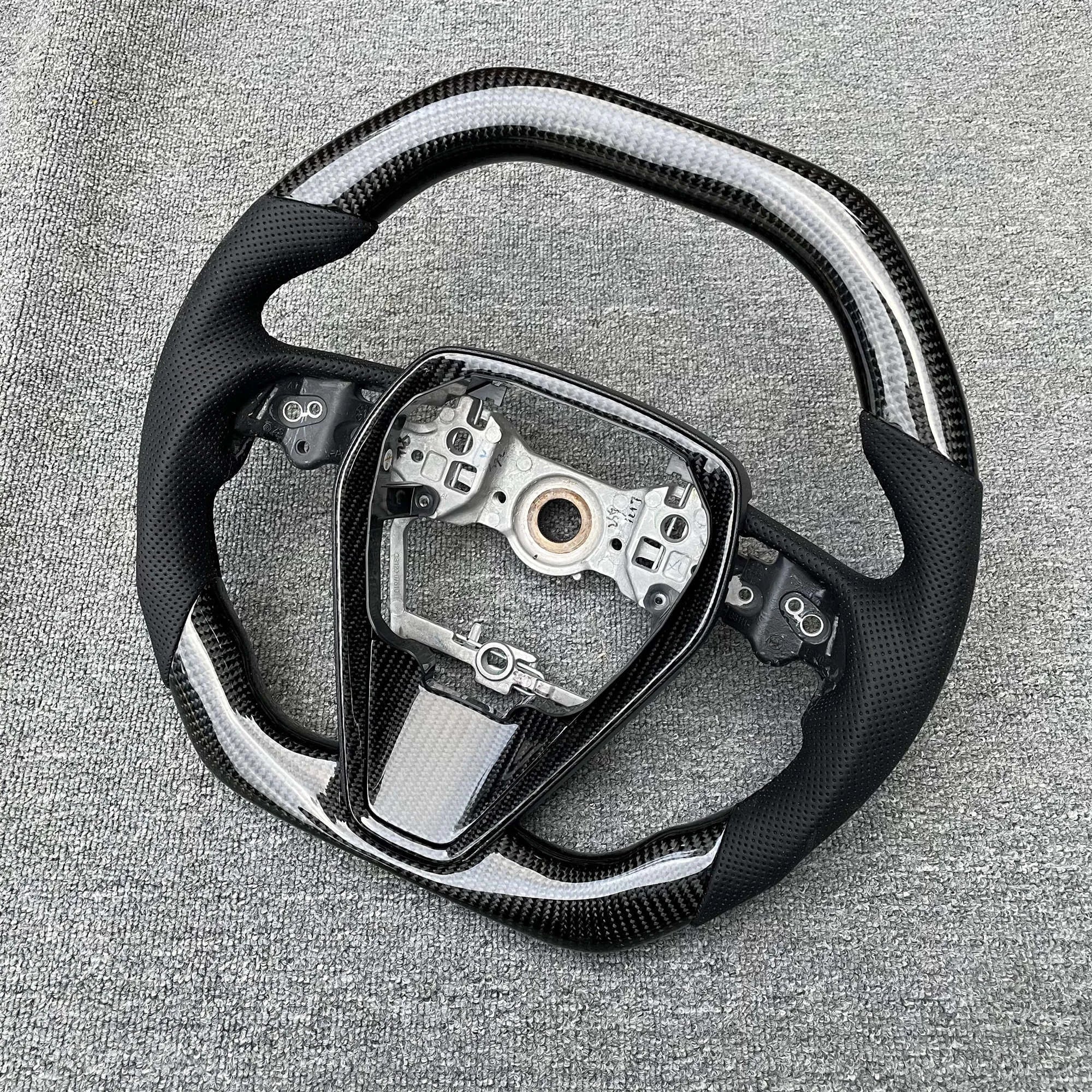 Eighth generation Toyota Camry carbon fiber steering wheel with colour style option shown on workbench